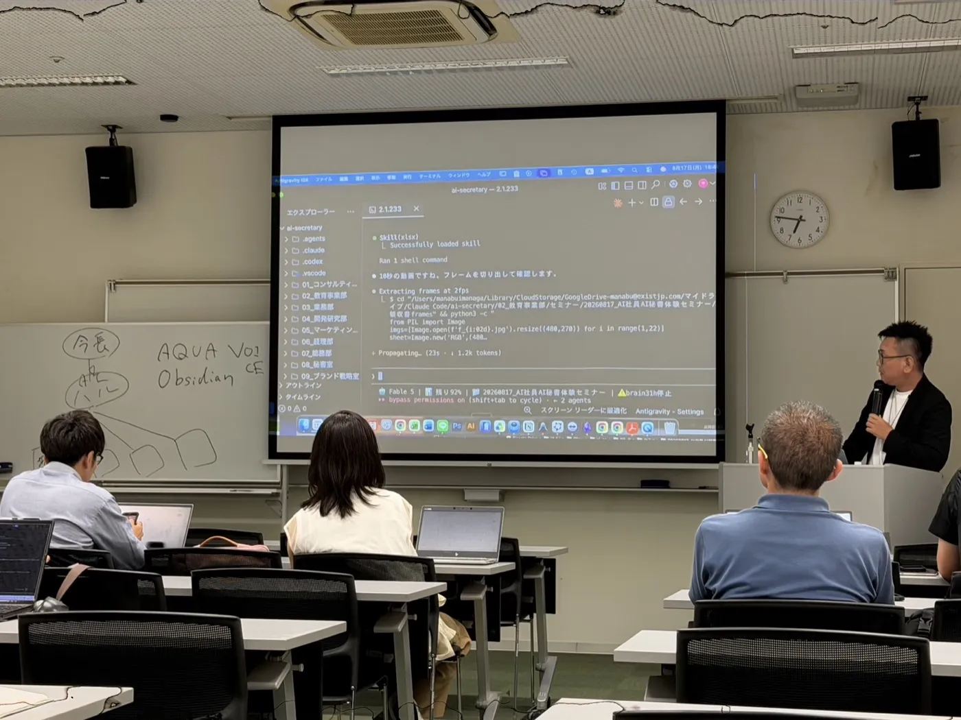 スクリーンにClaude Codeが動作している画面が映り、横のホワイトボードには「今長→ハル」「AQUA VOICE / Obsidian」と手書きされています