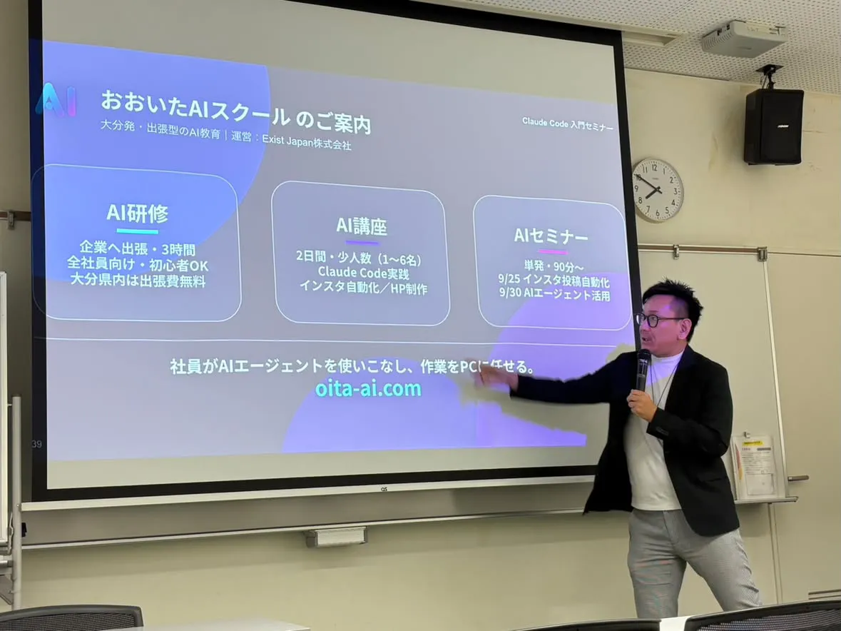 スクリーンに「おおいたAIスクールのご案内」としてAI研修・AI講座・AIセミナーの3つを映し、指し示しながら説明する今長学